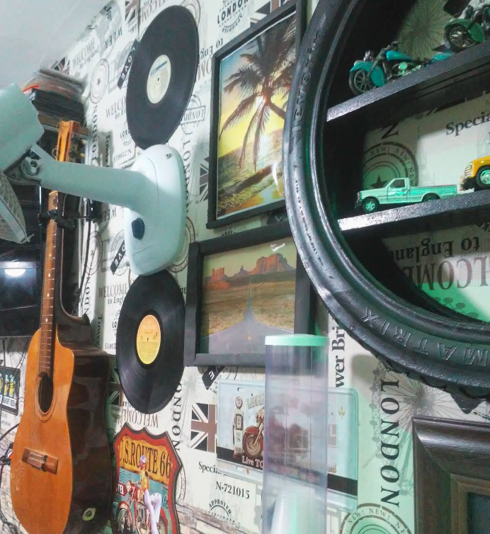 Parede vintage da barbearia com quadros, violões e tijolos aparentes